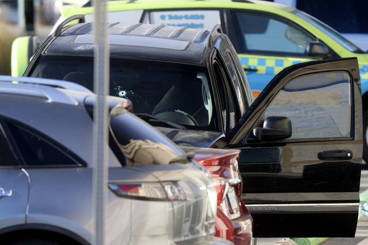 A stolen Jeep is seen with a bullet hole as Henderson Police investigate the scene of an office ...