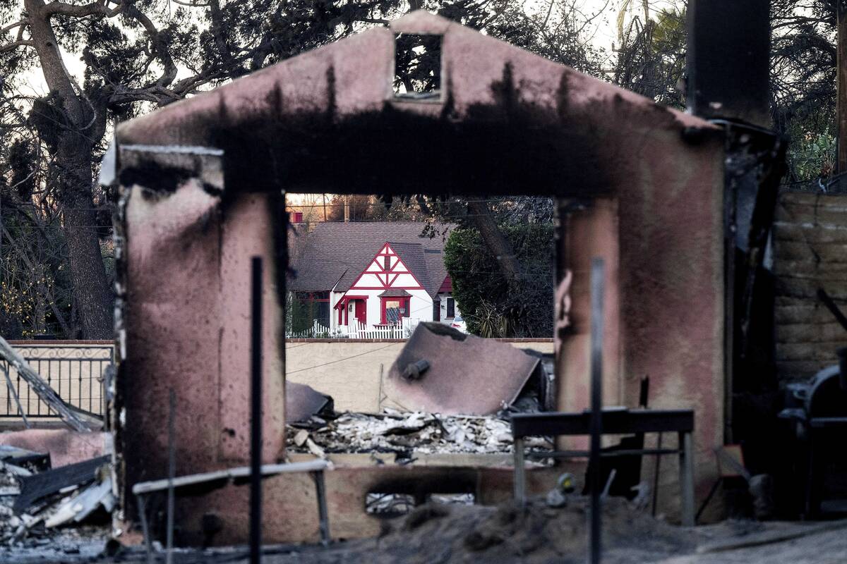 FILE - A home destroyed by the Eaton Fire stands in front of a home that survived in Altadena. ...