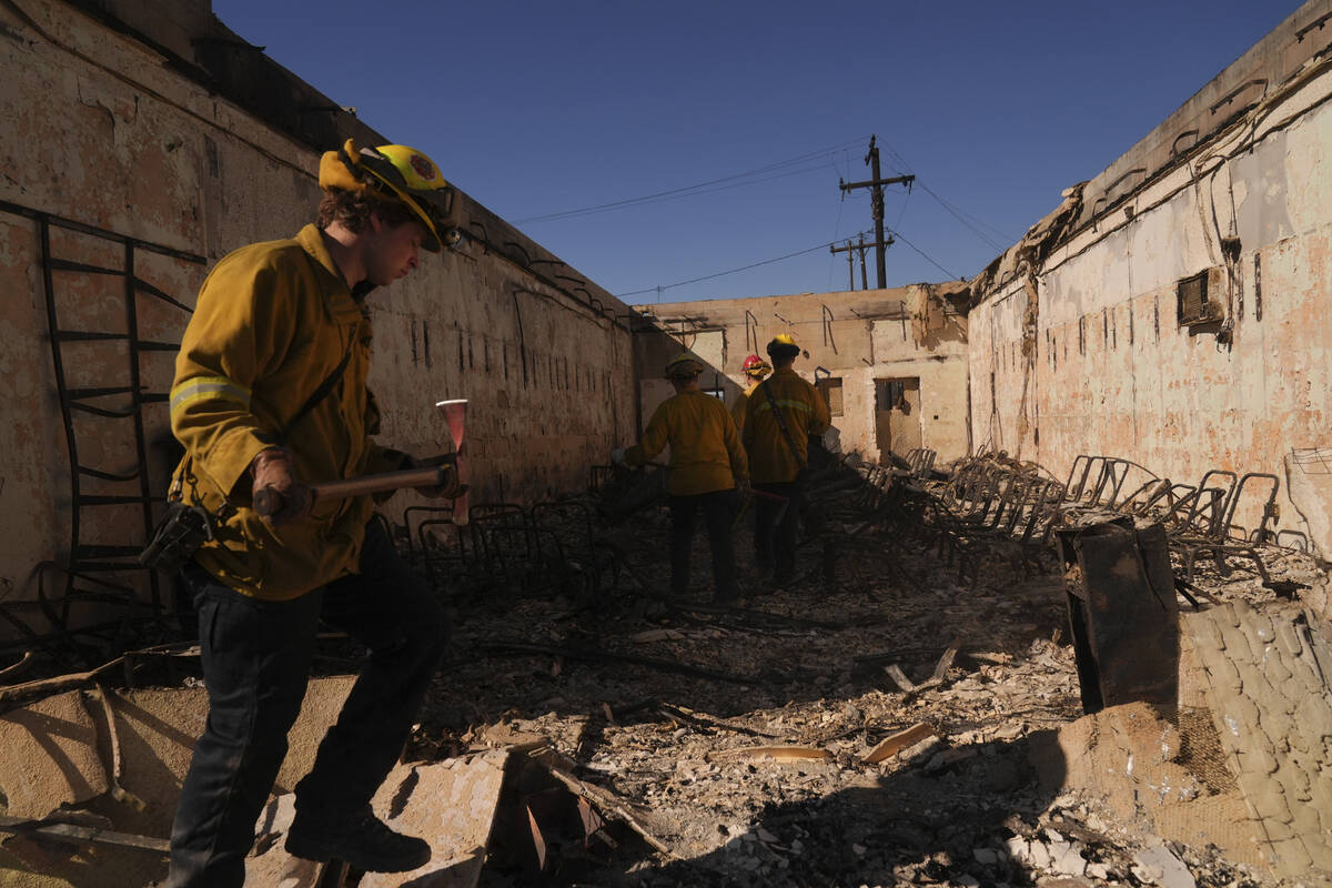 Search and rescue workers dig through the rubble left behind by the Eaton Fire, in Altadena, Ca ...