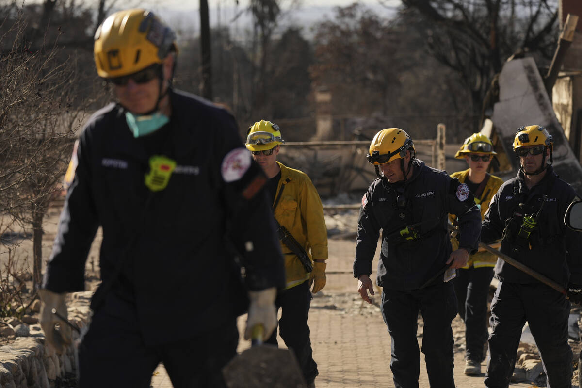 Search and rescue workers dig through the rubble left behind by the Eaton Fire, in Altadena, Ca ...