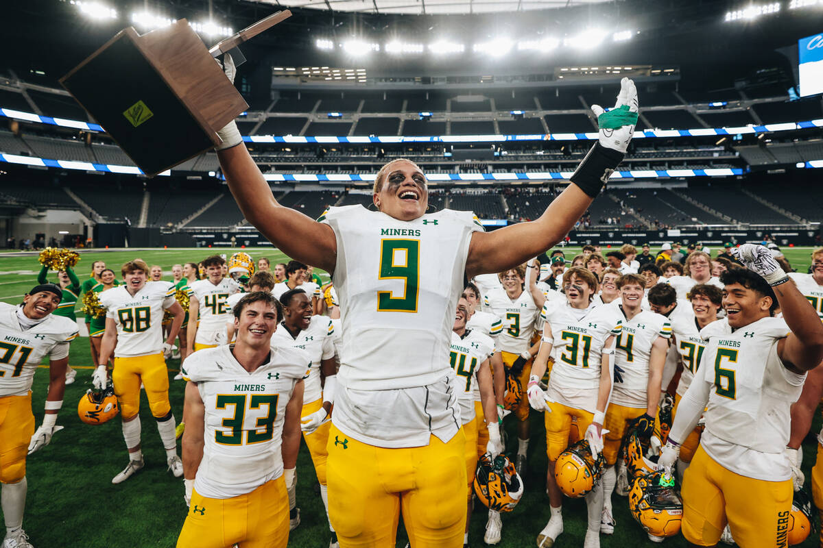 Bishop Manogue linebacker Marrio Williams Jr. (9) celebrates with a state championship trophy a ...