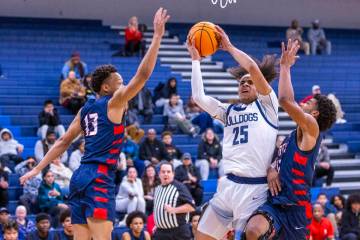 Centennial's Jayonni Durrough (25) elevates to shoot between Liberty's Jaden Riley (13) and Eva ...