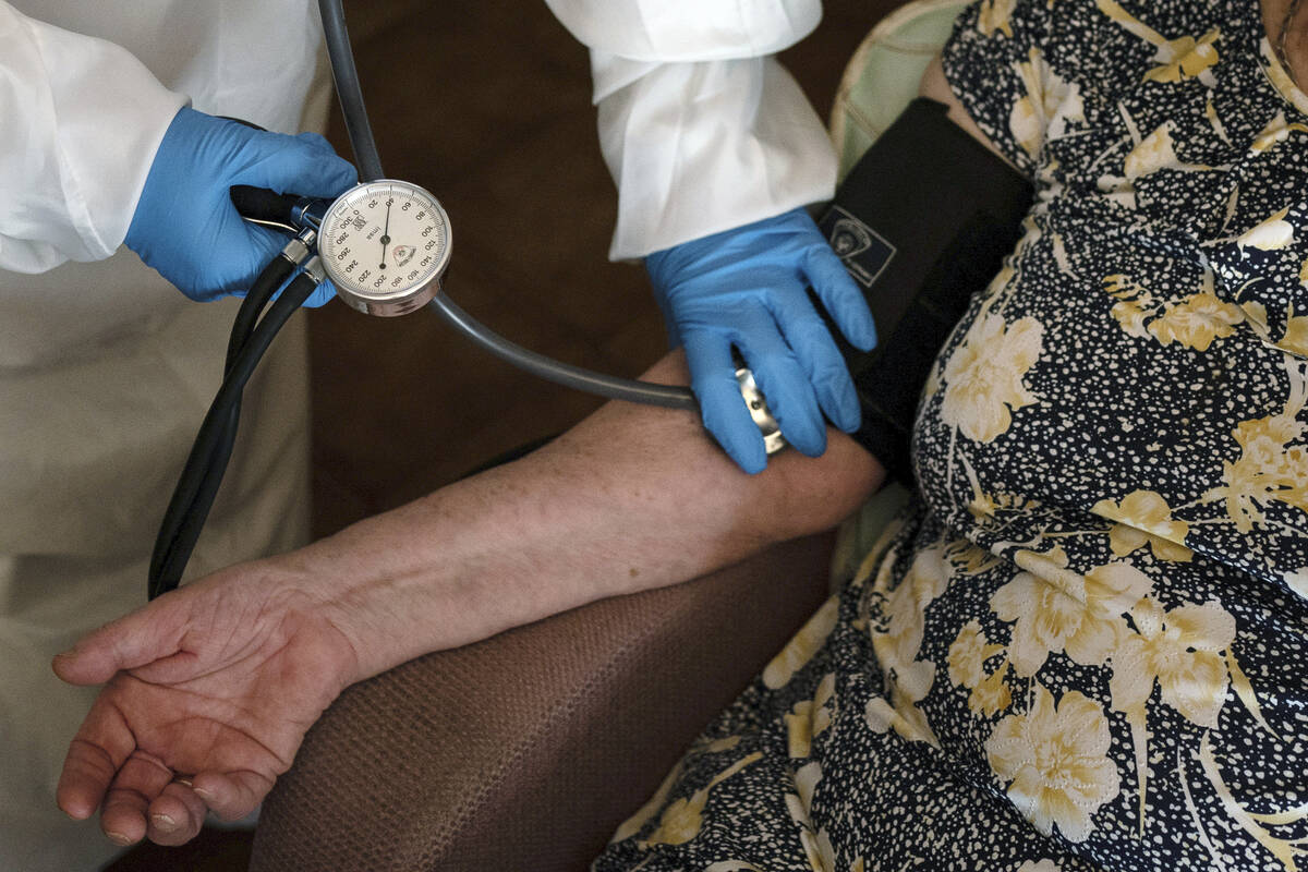 A doctor checks the blood pressure of A 94-year-old woman in Sant Sadurní d'Anoia, Catalonia r ...