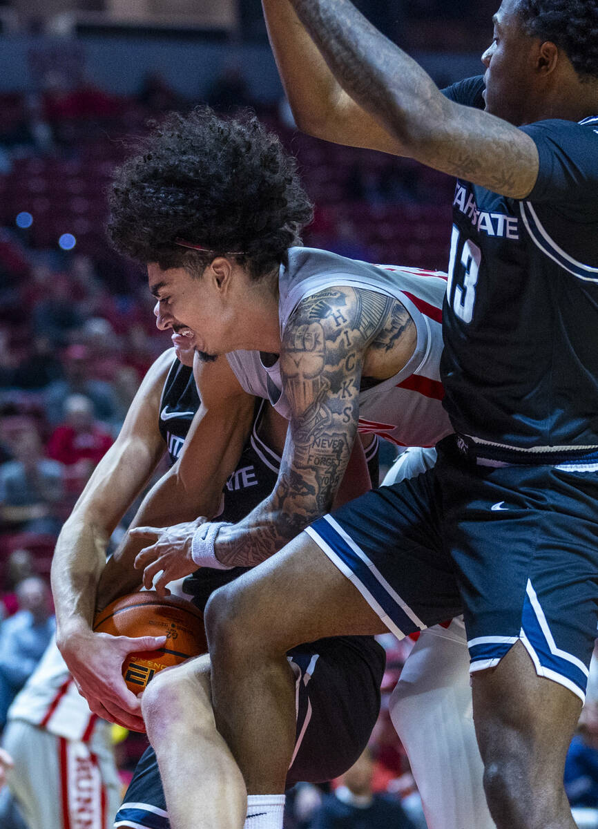 UNLV guard Brooklyn Hicks (13) fights for a loose ball with Utah State Aggies guard Deyton Albu ...