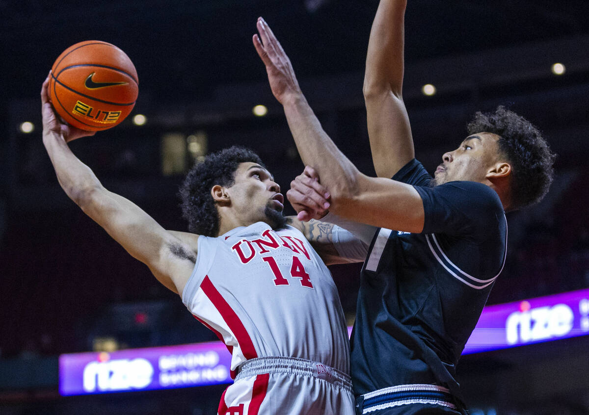 UNLV guard Jailen Bedford (14) takes on Utah State Aggies center Aubin Gateretse (21) on his wa ...