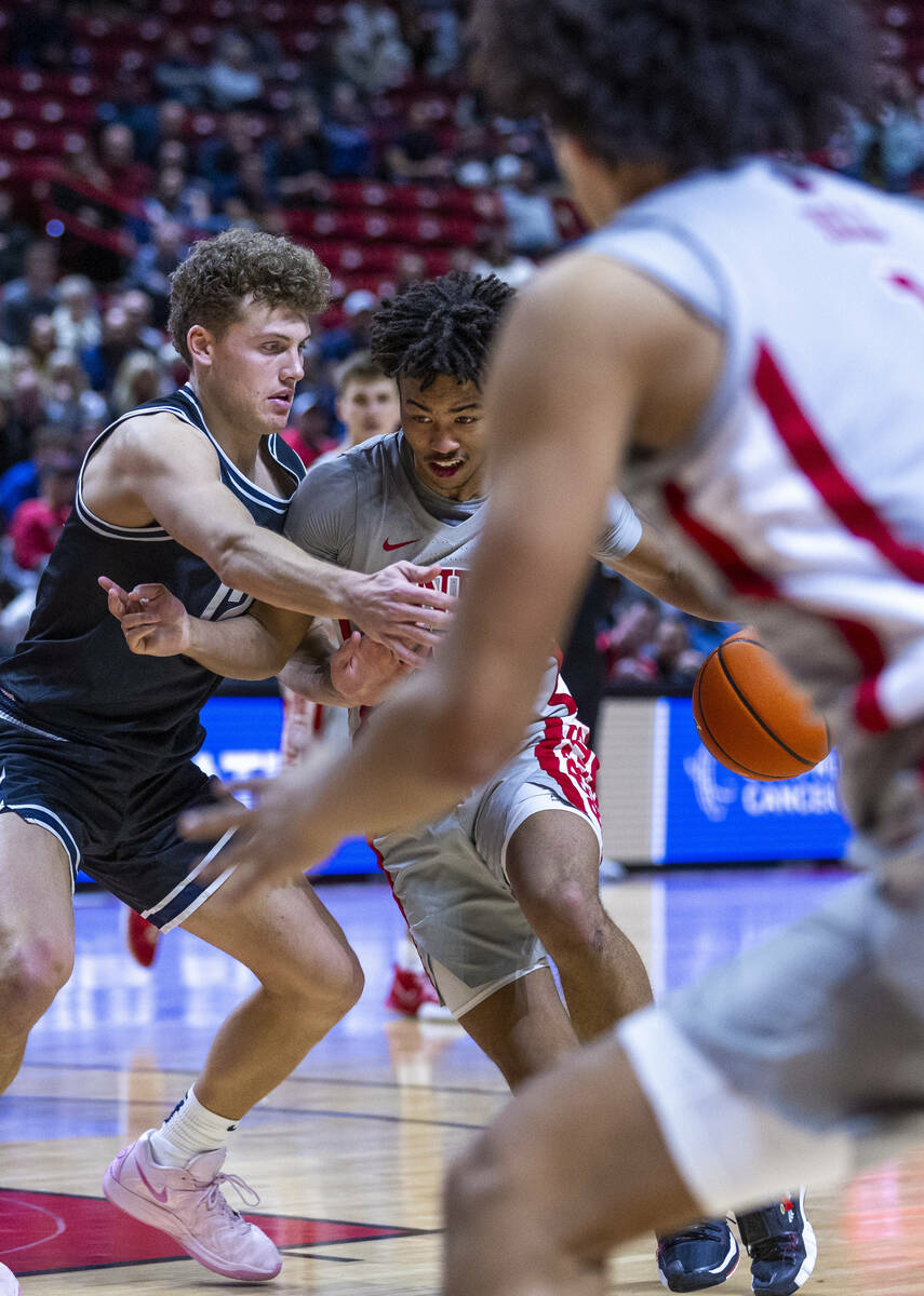 UNLV guard Dedan Thomas Jr. (11) battles in the lane on a drive against Utah State Aggies guard ...