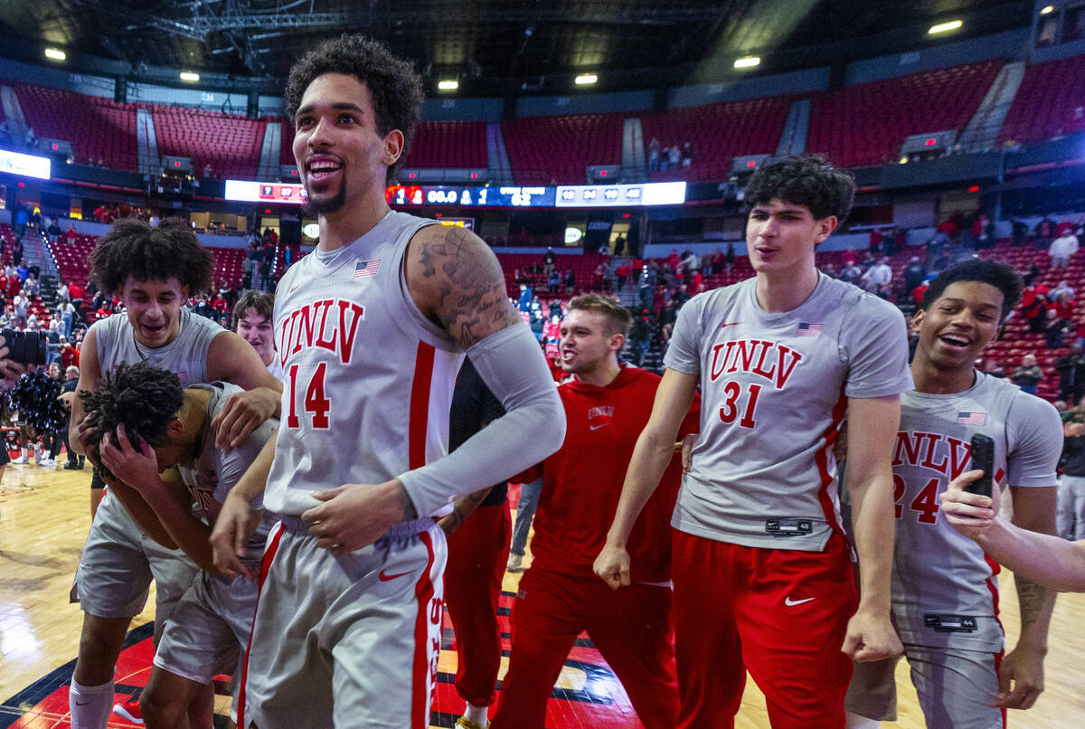 UNLV players celebrate their win against the Utah State Aggies following their NCAA men's baske ...