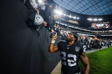 Raiders running back Alexander Mattison (22) walks by fans after signing autographs following a ...