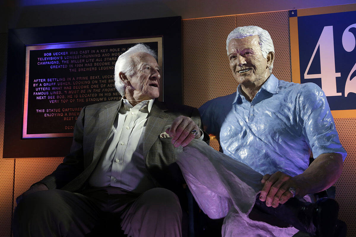 Milwaukee Brewers radio announcer Bob Uecker sits next to his statue Friday, April 25, 2014, at ...