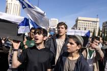 Israeli youths chant slogans and carry mock coffins draped in Israel's national flag during a p ...