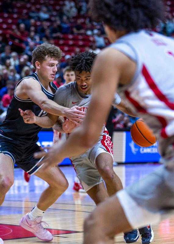 UNLV guard Dedan Thomas Jr. (11) battles in the lane on a drive against Utah State Aggies guard ...