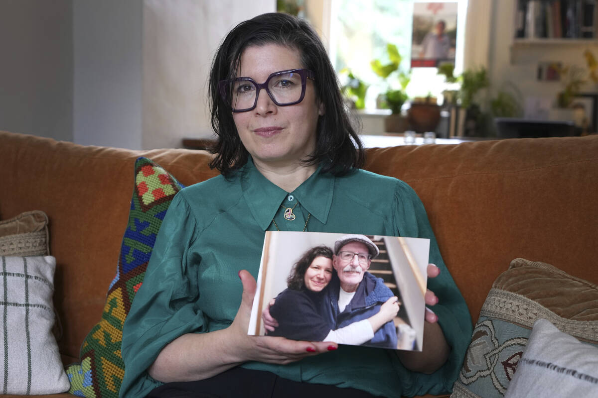 Sharone Lifschitz holds a photograph of herself with her father, Oded Lifshitz, who was abducte ...