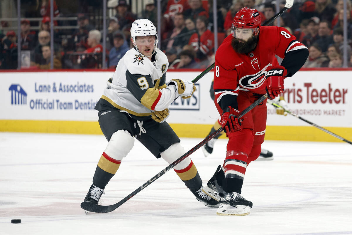 Carolina Hurricanes' Brent Burns (8) clears the puck from Vegas Golden Knights' Jack Eichel (9) ...