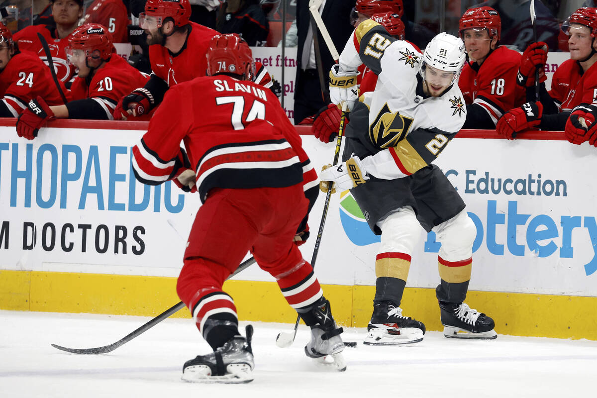 Vegas Golden Knights' Brett Howden (21) tries to control the puck with Carolina Hurricanes' Jac ...