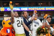 Notre Dame linebacker Jack Kiser (24), left, throws oranges to his teammates after winning the ...