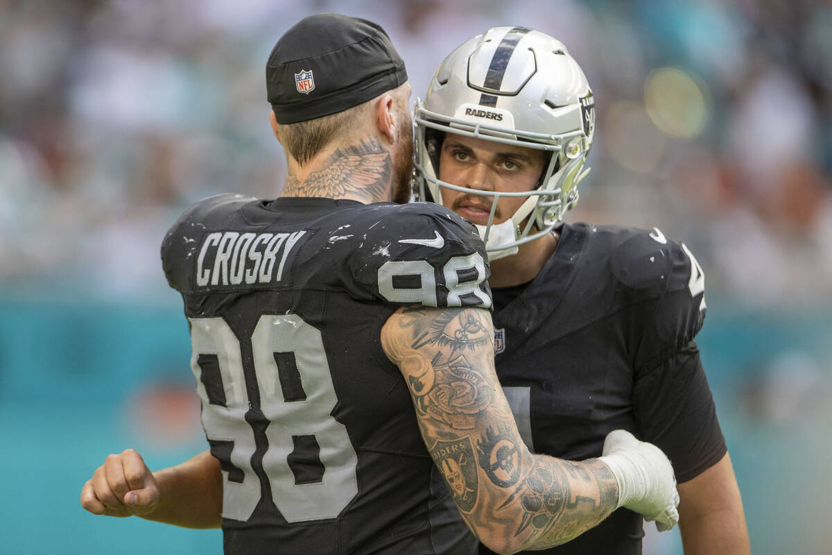 Raiders defensive end Maxx Crosby (98) hugs Raiders quarterback Aidan O'Connell (4) during the ...