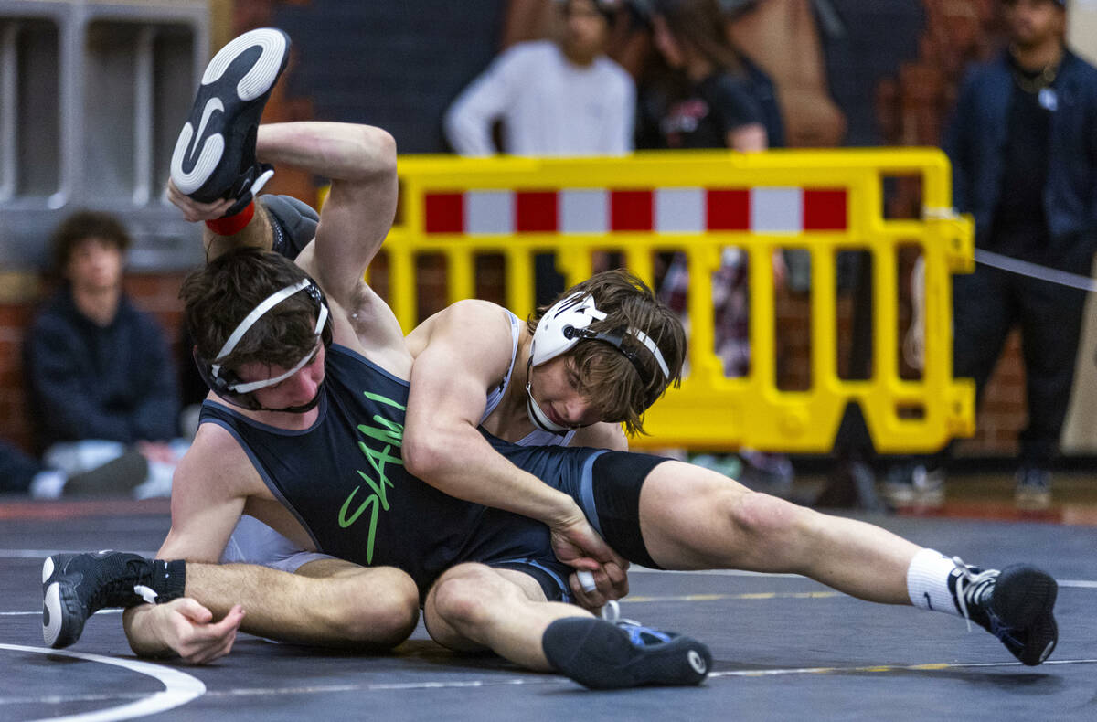 SLAM's Drake Hooiman and Faith Lutheran's Cade Cook fight for position on the mat during their ...