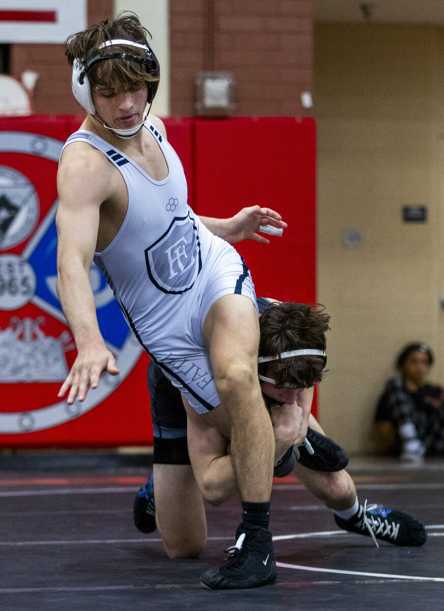 Faith Lutheran's Cade Cook works to break a leg hold by SLAM's Drake Hooiman during their 144 l ...