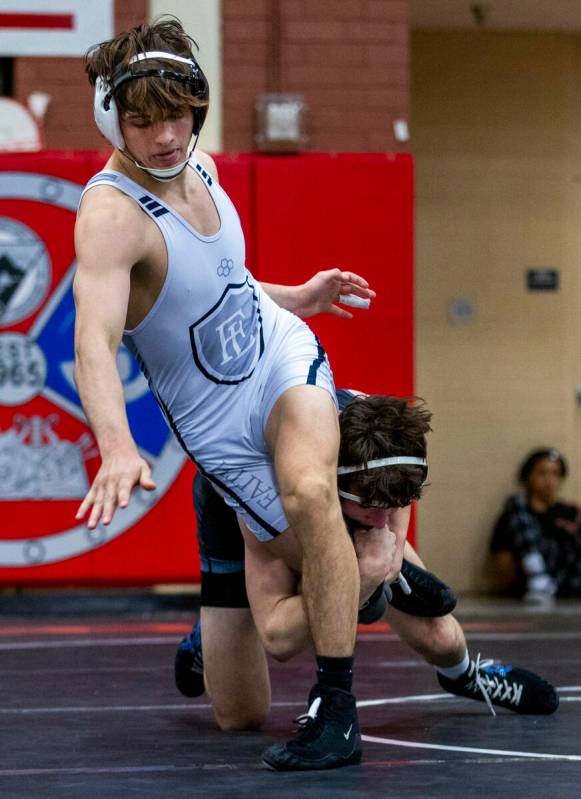 Faith Lutheran's Cade Cook works to break a leg hold by SLAM's Drake Hooiman during their 144 l ...