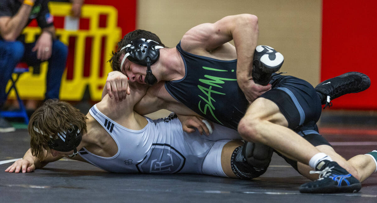 Faith Lutheran's Cade Cook works to escape a hold by SLAM's Drake Hooiman during their 144 lb. ...