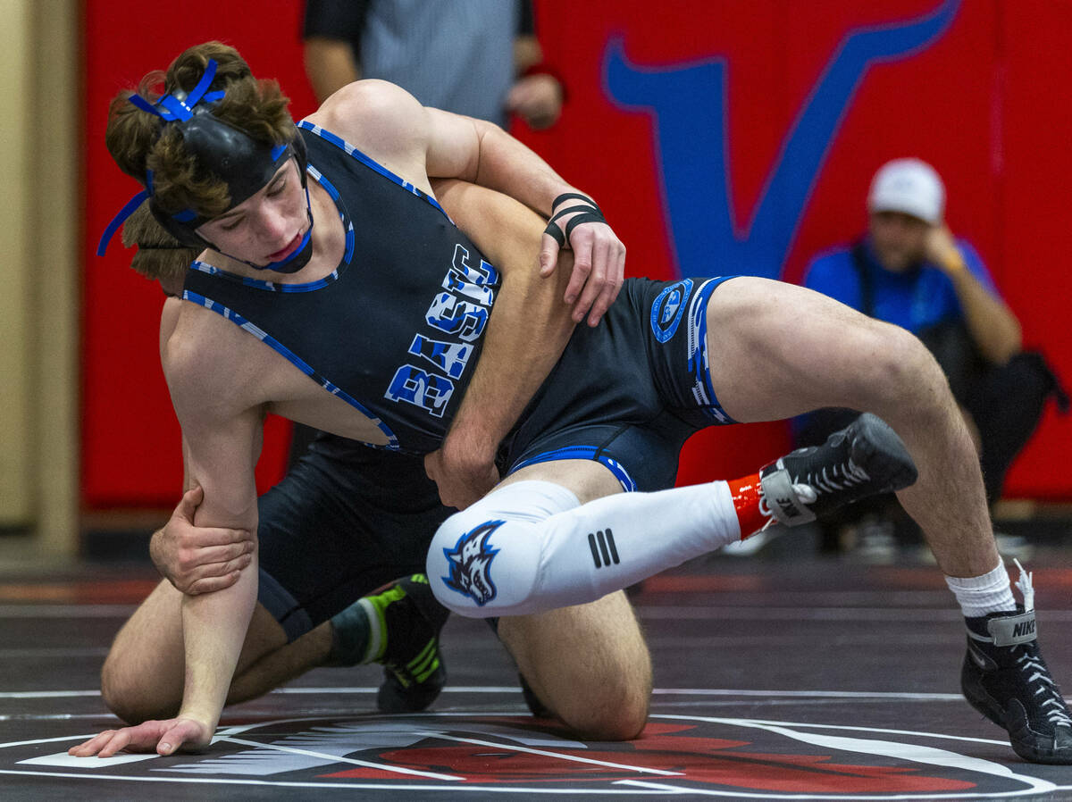 Basic's Jaxon Mackey is grabbed from behind by SLAM's Isaac Balden during their 150 lb. finals ...