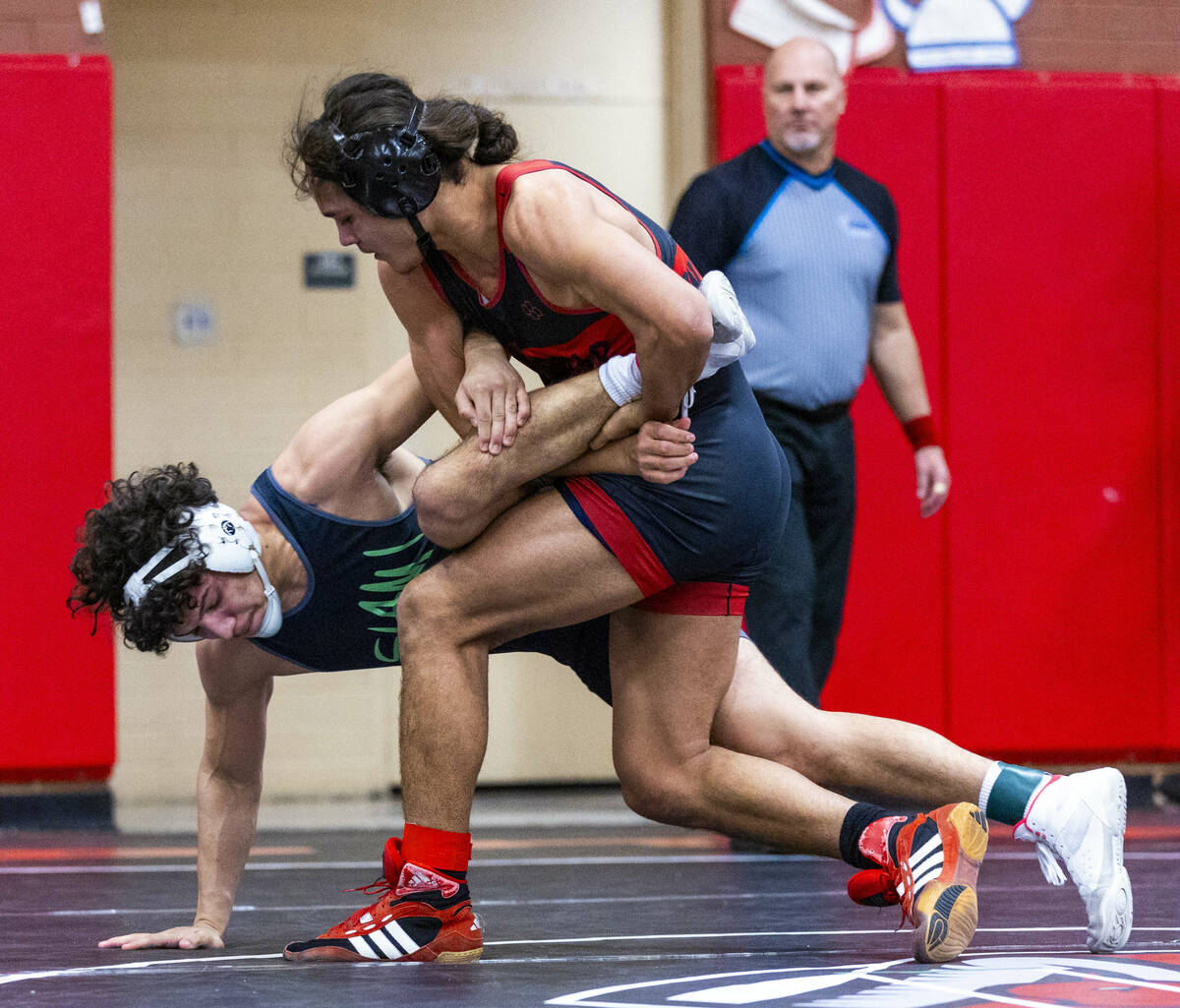 SLAM's Gabriel Delgado is wrapped up as Las Vegas High's Leonard Castellanos works to take him ...