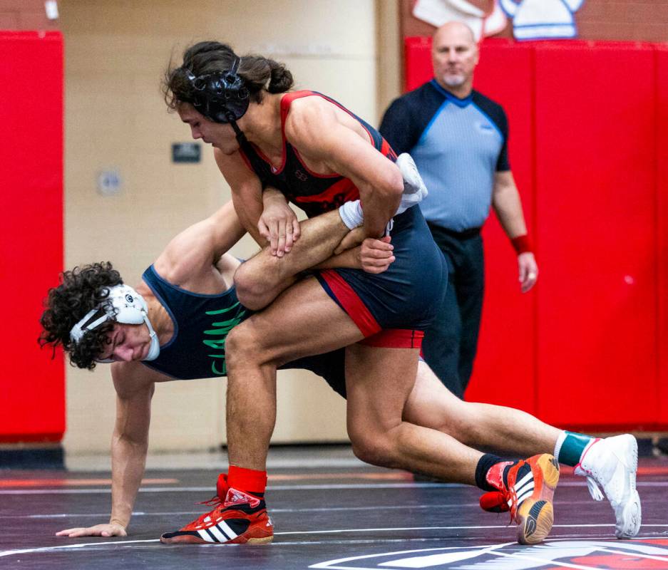 SLAM's Gabriel Delgado is wrapped up as Las Vegas High's Leonard Castellanos works to take him ...