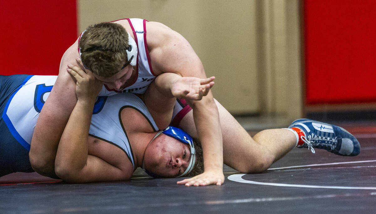 Desert Oasis' Benjamin Young works to pin Basic's Tyler Jahrling during their 285 lb. finals ma ...