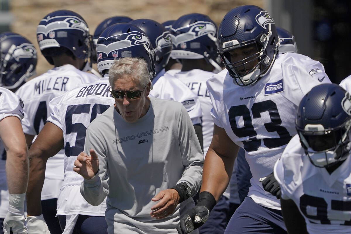 Seattle Seahawks head coach Pete Carroll, center, looks on as players, including defensive tack ...