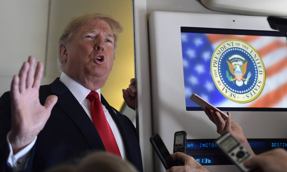 FILE - President Donald Trump talks to reporters while in flight from Billings, Mont., to Fargo ...