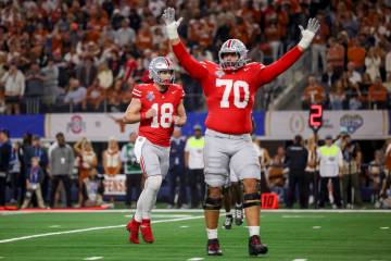 Ohio State quarterback Will Howard (18) and offensive lineman Josh Fryar (70) celebrates after ...