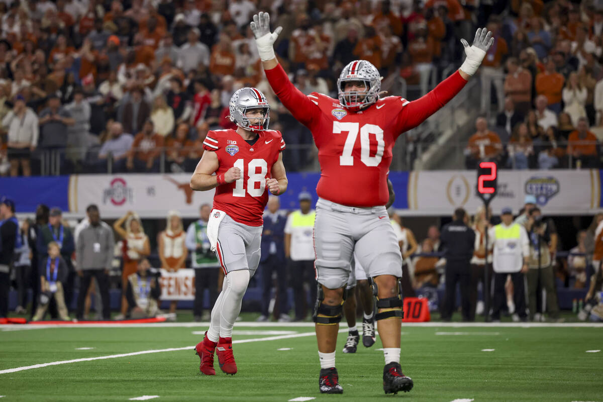 Ohio State quarterback Will Howard (18) and offensive lineman Josh Fryar (70) celebrates after ...