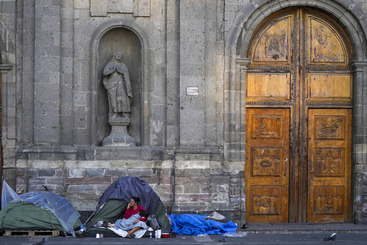 A Venezuelan migrant wakes up at a migrant tent camp outside La Soledad church in Mexico City, ...