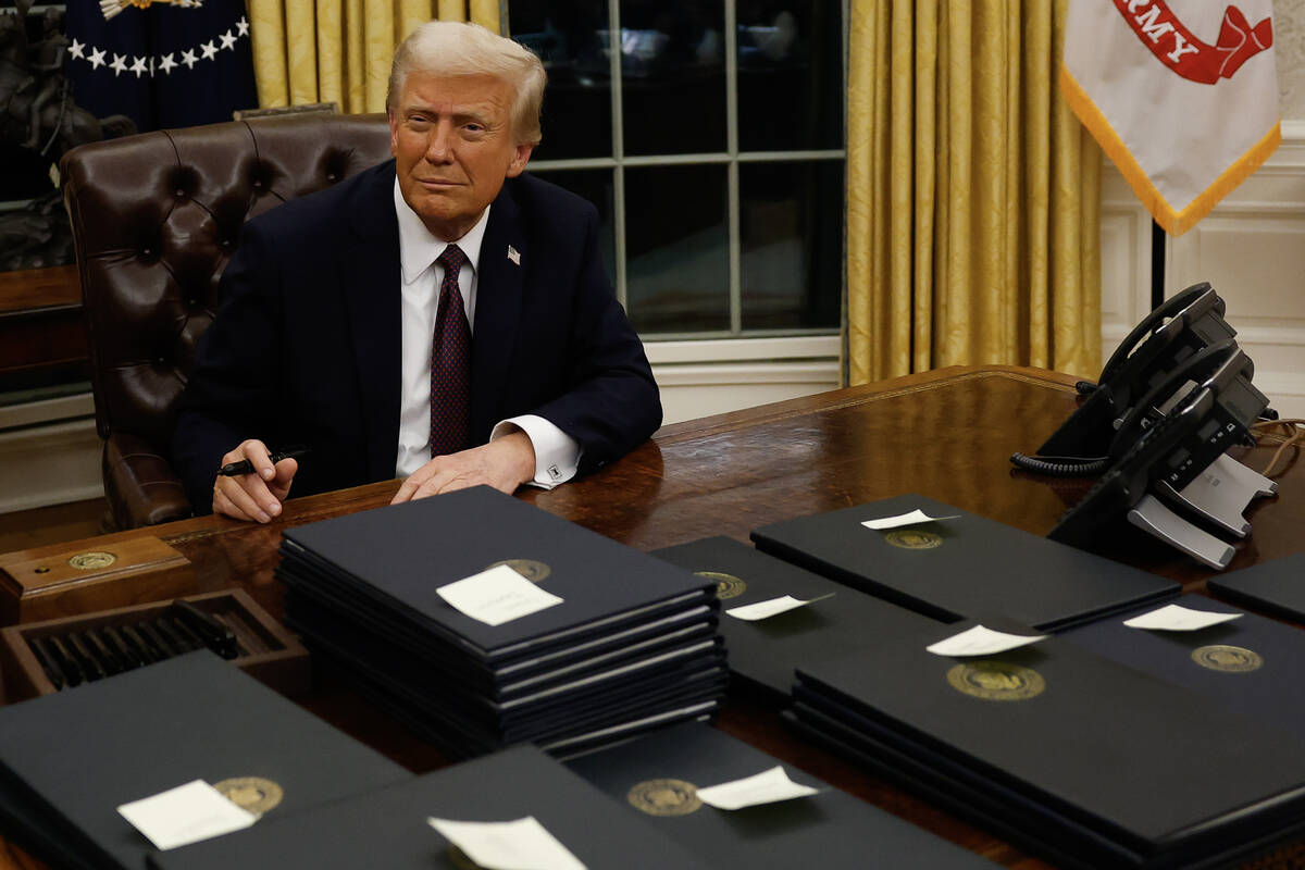 President Donald Trump signs executive orders in the Oval Office on Monday, Jan. 20, 2025, in W ...