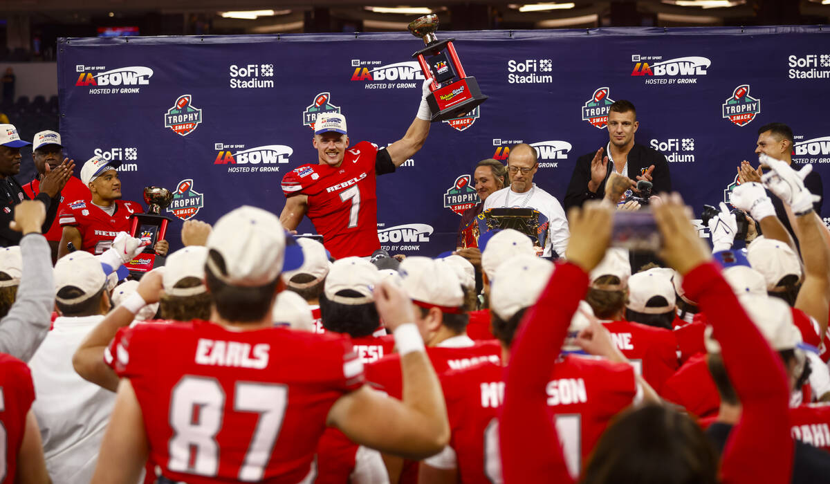 UNLV linebacker Jackson Woodard (7) lifts the trophy for best defensive player in the LA Bowl a ...