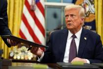 President Donald Trump signs executive orders in the Oval Office of the White House, Monday, Ja ...