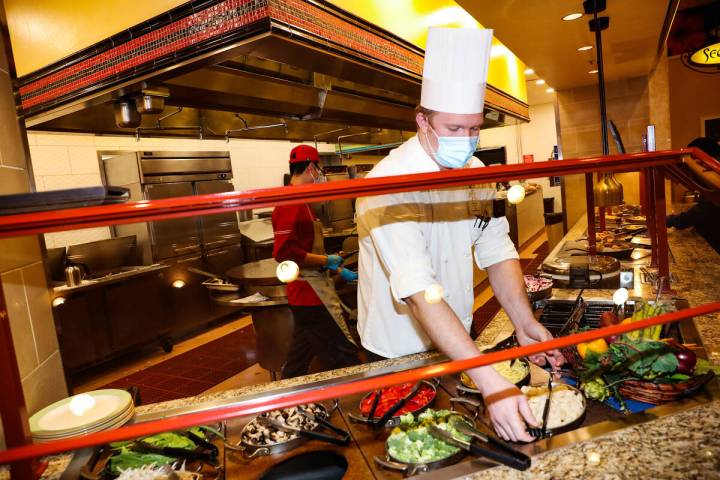 Sous Chef Tanner Gross puts out vegetables for guests to choose from at the Mongolian Grill at ...