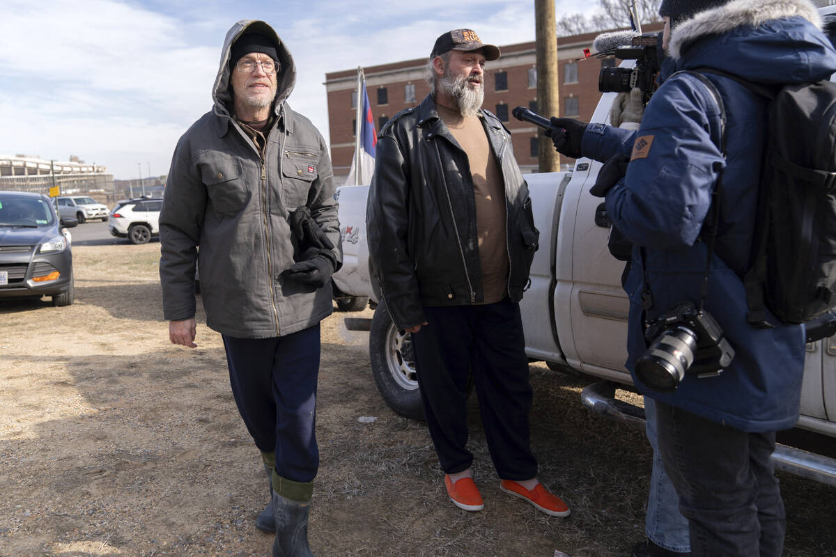 Supporters of President Donald Trump, Kevin Loftus, left and William Sarsfield III, center, who ...