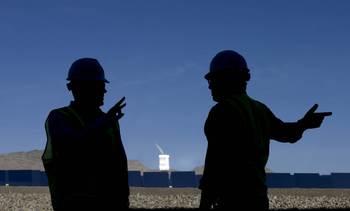 Jeff Holland, right, talks with Noel Hanson near boilers that sit on 459-foot towers at the Iva ...