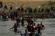 Migrants, many from Haiti, wade across the Rio Grande from Del Rio, Texas. (AP Photo/Fernando L ...