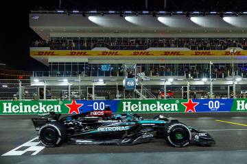 Mercedes driver George Russell crosses the finish line as the flag waves in the tower winning t ...