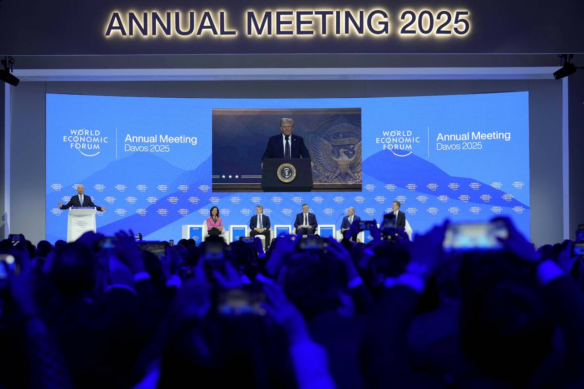 People follow a virtual speech of U.S. president Donald Trump at the Annual Meeting of World Ec ...