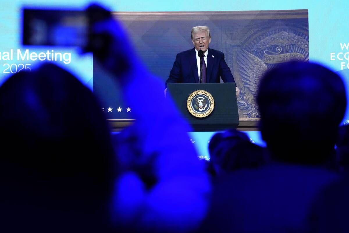 People follow a virtual speech of U.S. president Donald Trump at the Annual Meeting of World Ec ...