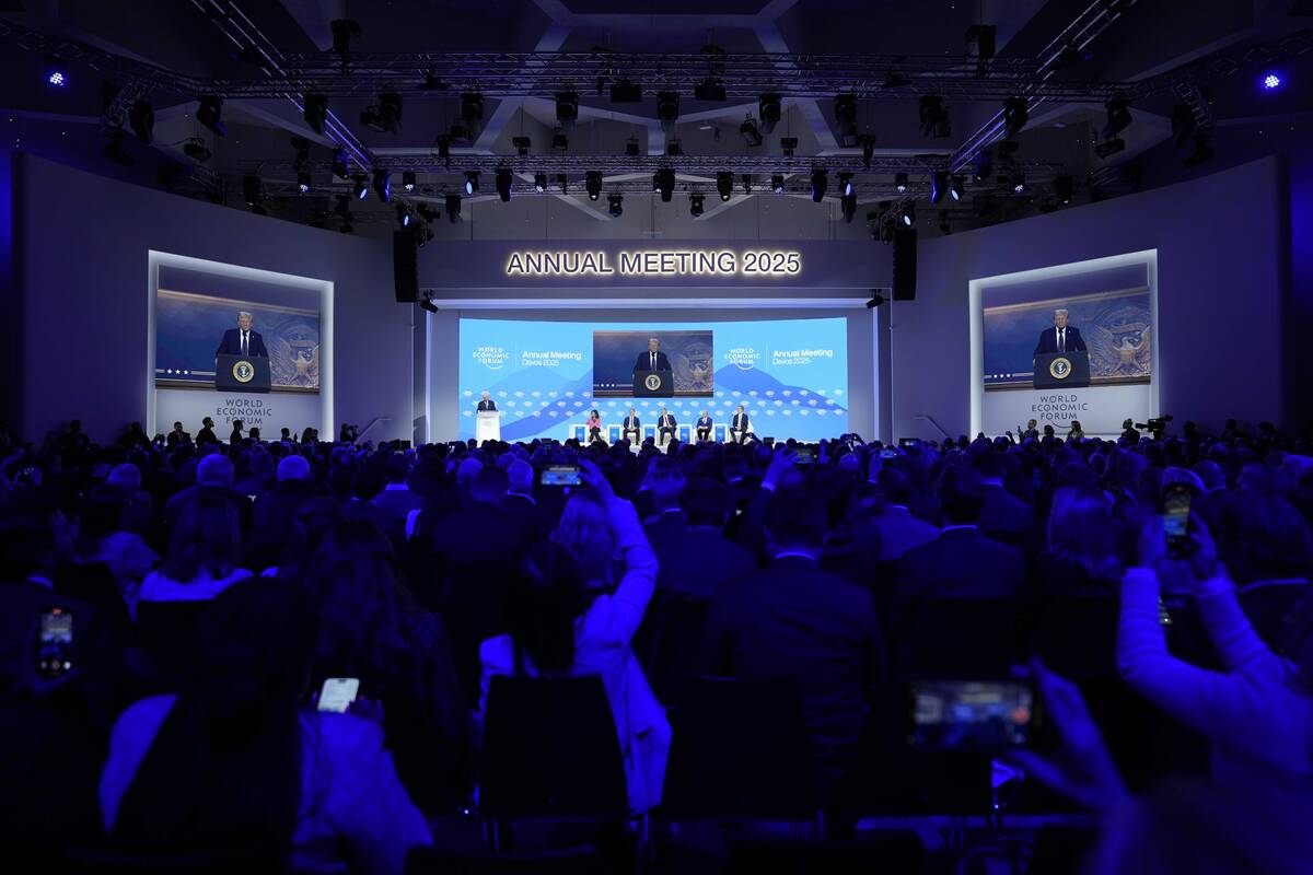 People follow a virtual speech of U.S. president Donald Trump at the Annual Meeting of World Ec ...