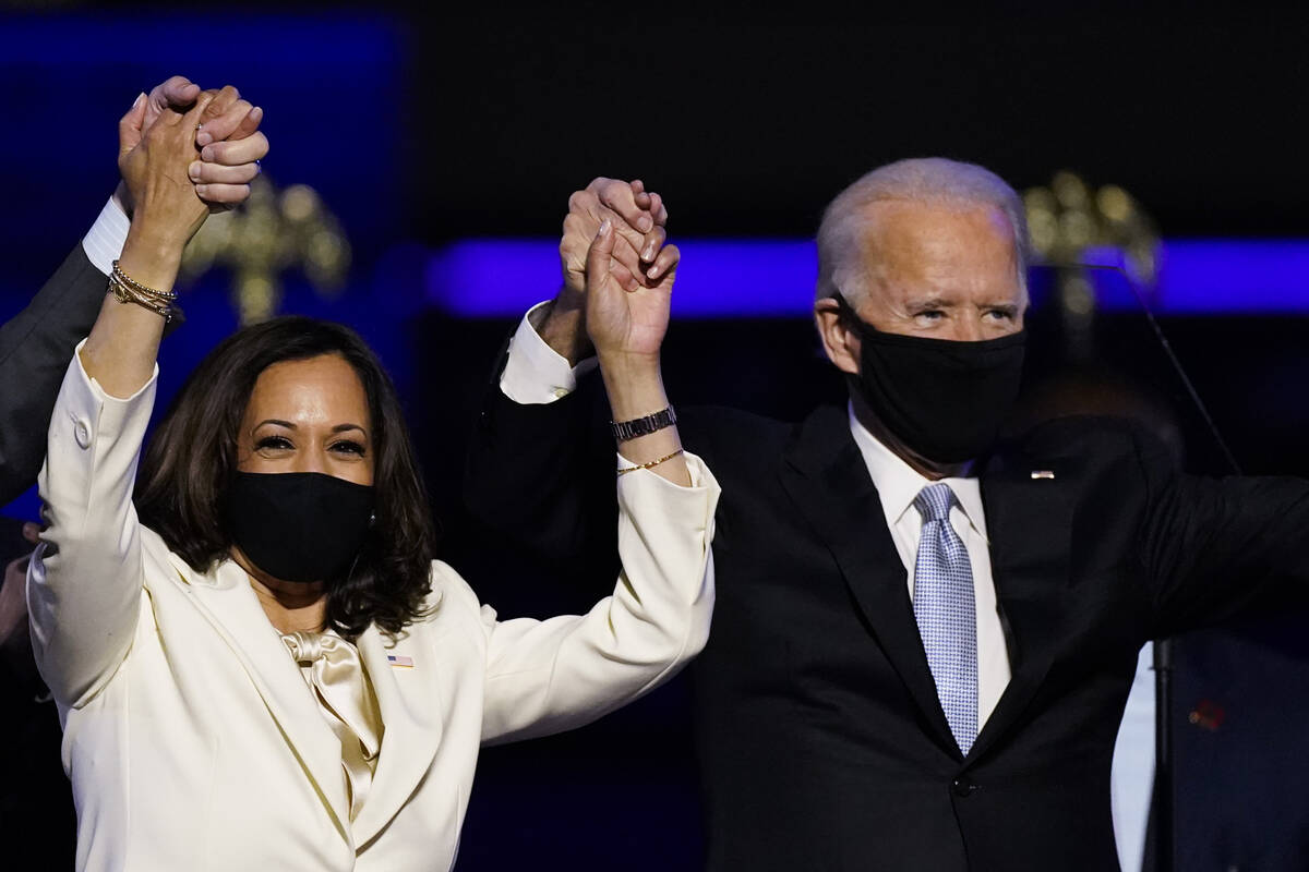 Vice President-elect Kamala Harris holds hands with President Joe Biden. (AP Photo/Andrew Harni ...