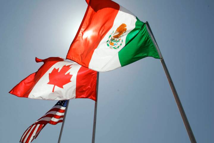 National flags representing the United States, Canada, and Mexico fly in the breeze. (AP Photo/ ...