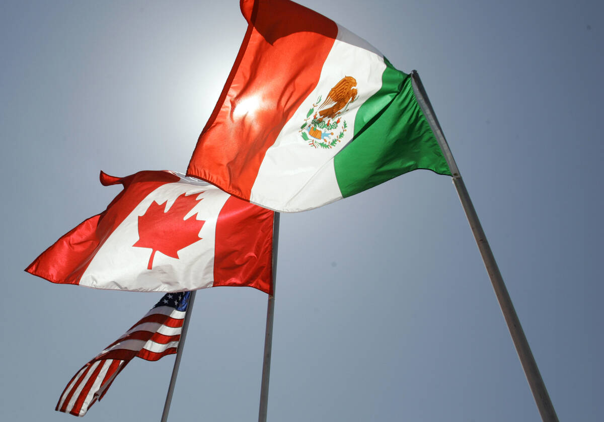 National flags representing the United States, Canada, and Mexico fly in the breeze. (AP Photo/ ...