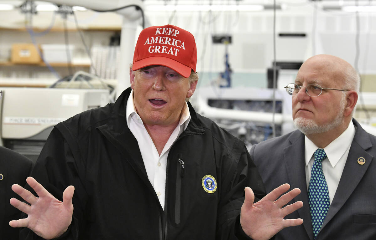 FILE - President Donald Trump speaks to members of the press as Director Robert Redfield, right ...