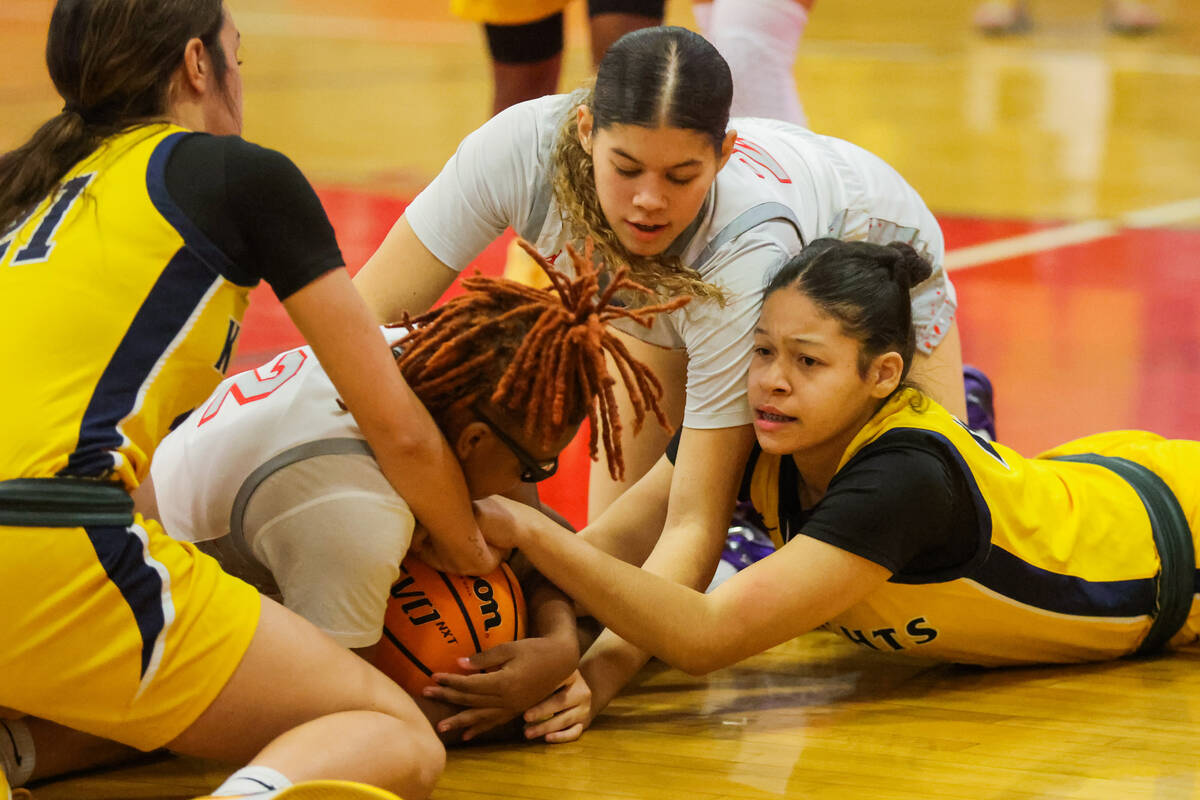 Players struggle over the ball during a girls basketball game between Democracy Prep and Libert ...