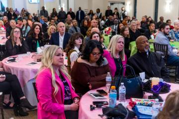 Family members and friends are moved as they watch a slideshow of images during a remembrance g ...